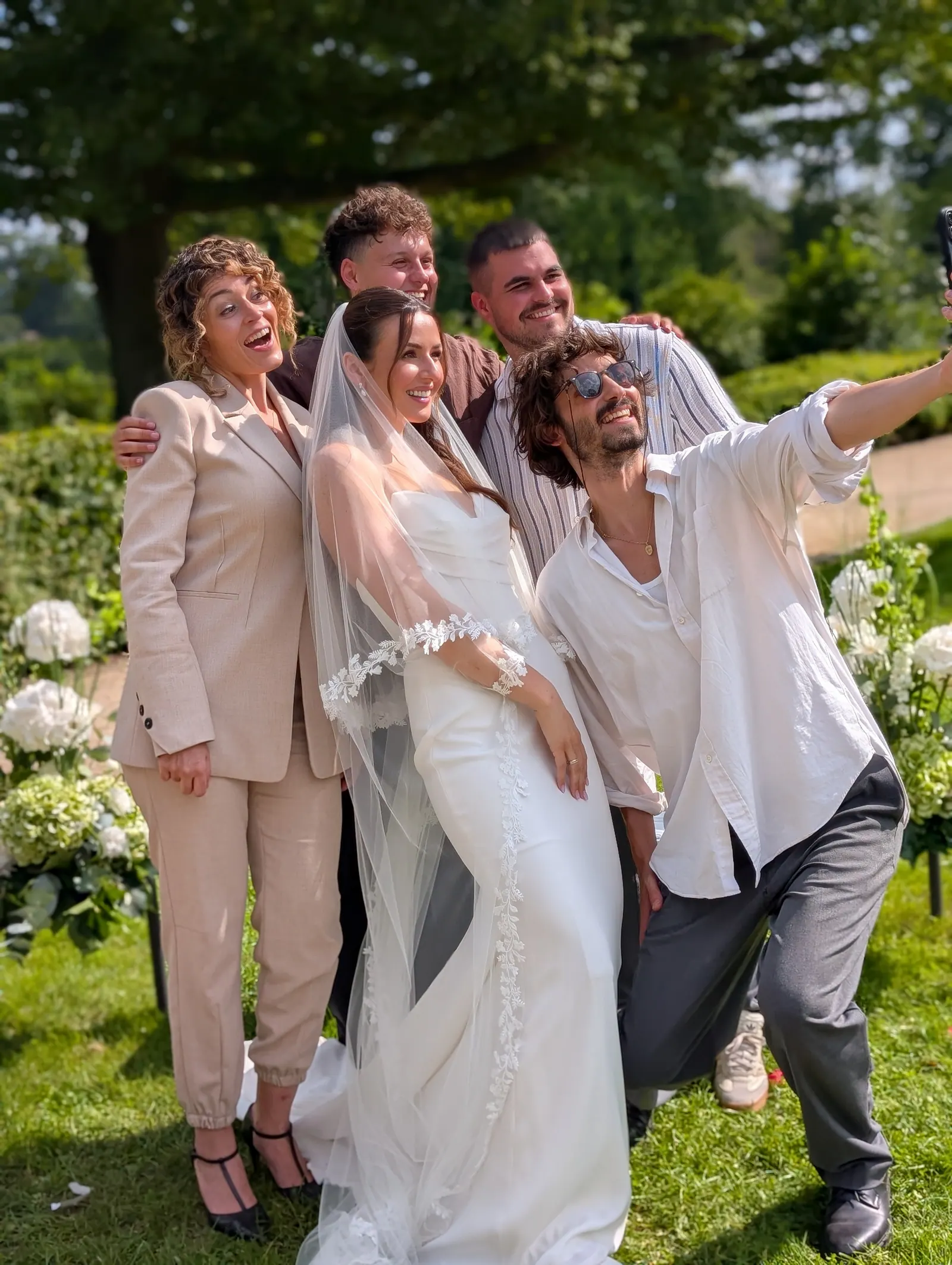 Ximena and a wedding group sharing a joyful moment in a sunny garden