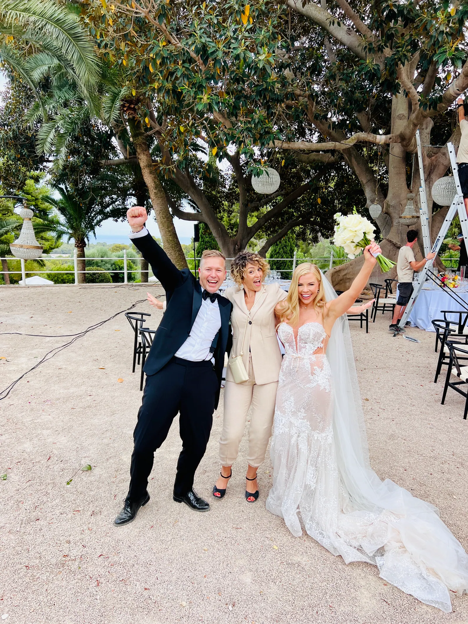 A newly married couple and Ximena celebrating together in a garden
